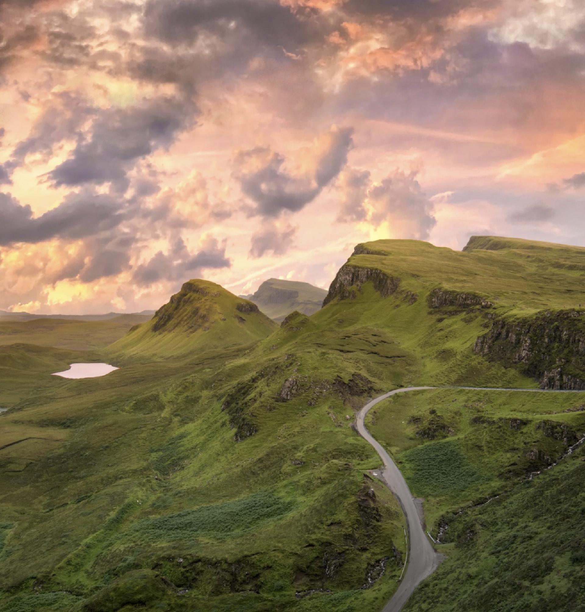A winding road through mountains at sunrise